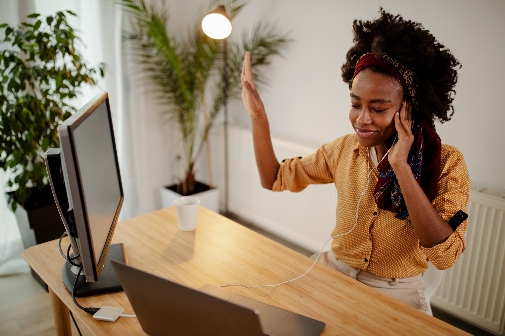 Freelance Afro American girl enjoys music in headphones.